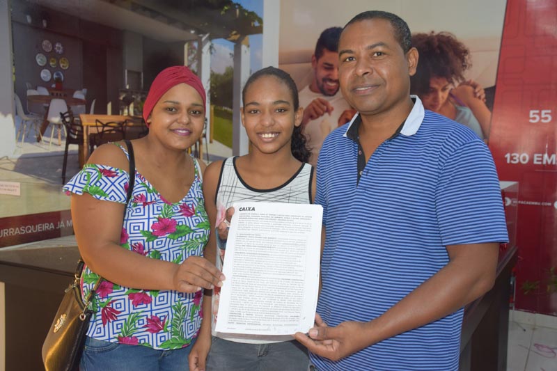 Ailton Teixeira, junto com a esposa Daiane e a filha Vitória comemoram o contrato da casa própria